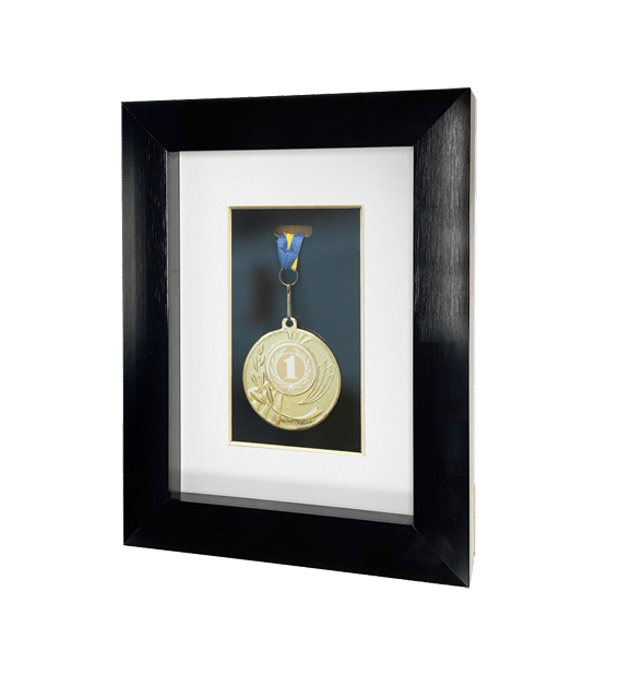 Gold medal with number one in a black shadow box frame with white matting.