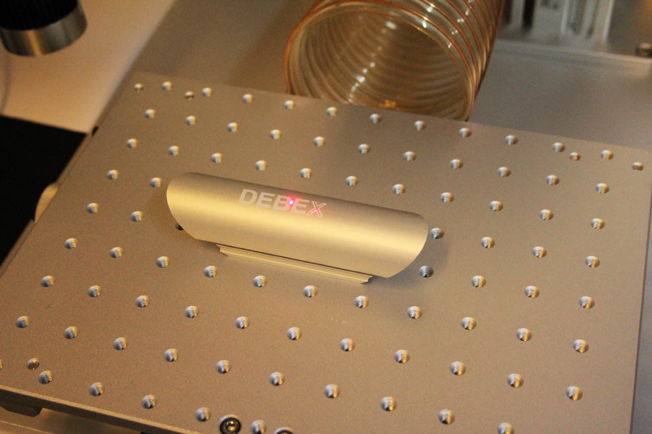 Laser engraving brand logo DEBEX on a metal part